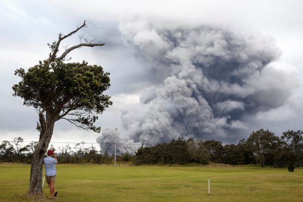 A man watches as ash erupts from the Halemaumau crater near the community of Volcano during ongoing eruptions of the Kilauea Volcano in Hawaii, U.S., May 15, 2018. (Reuters/Terray Sylvester)