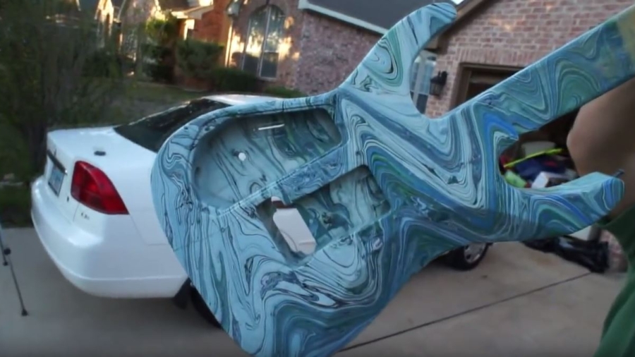 Need to paint a guitar? Get a trash bin full of water and some paint