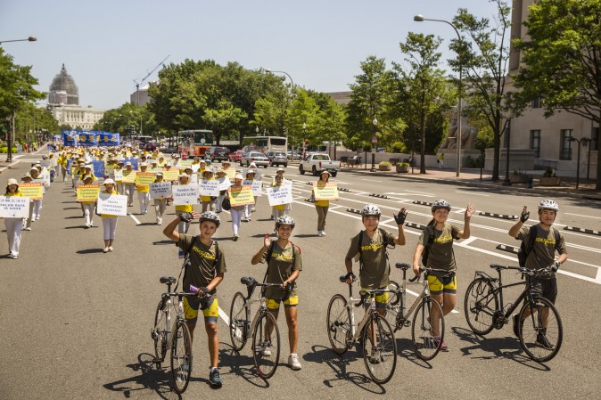 The Ride2Freedom team walk their bikes after joining the Falun Gong parade in Washington on July 16 after their ride across the country. (Edward Dye/Epoch Times)