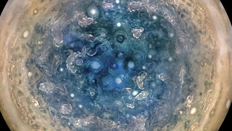 Peaking underneath Jupiter’s cloud cover reveals enormous cyclones spinning