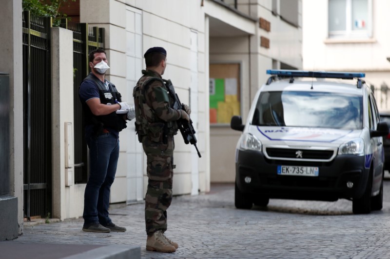 A police investigator and an armed soldier work near the scene where French soliders were hit and injured by a vehicle in the western Paris suburb of Levallois-Perret, France on Aug. 9, 2017. (Benoit Tessier/Reuters)