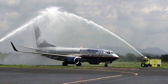 An Aeromexico plane crosses below an arc of water made by firefighters to mark the Mexico-Managua nonstop inaugural flight 04 June 4, 2007, in Managua.(Miguel Alverez/AFP/Getty Images)