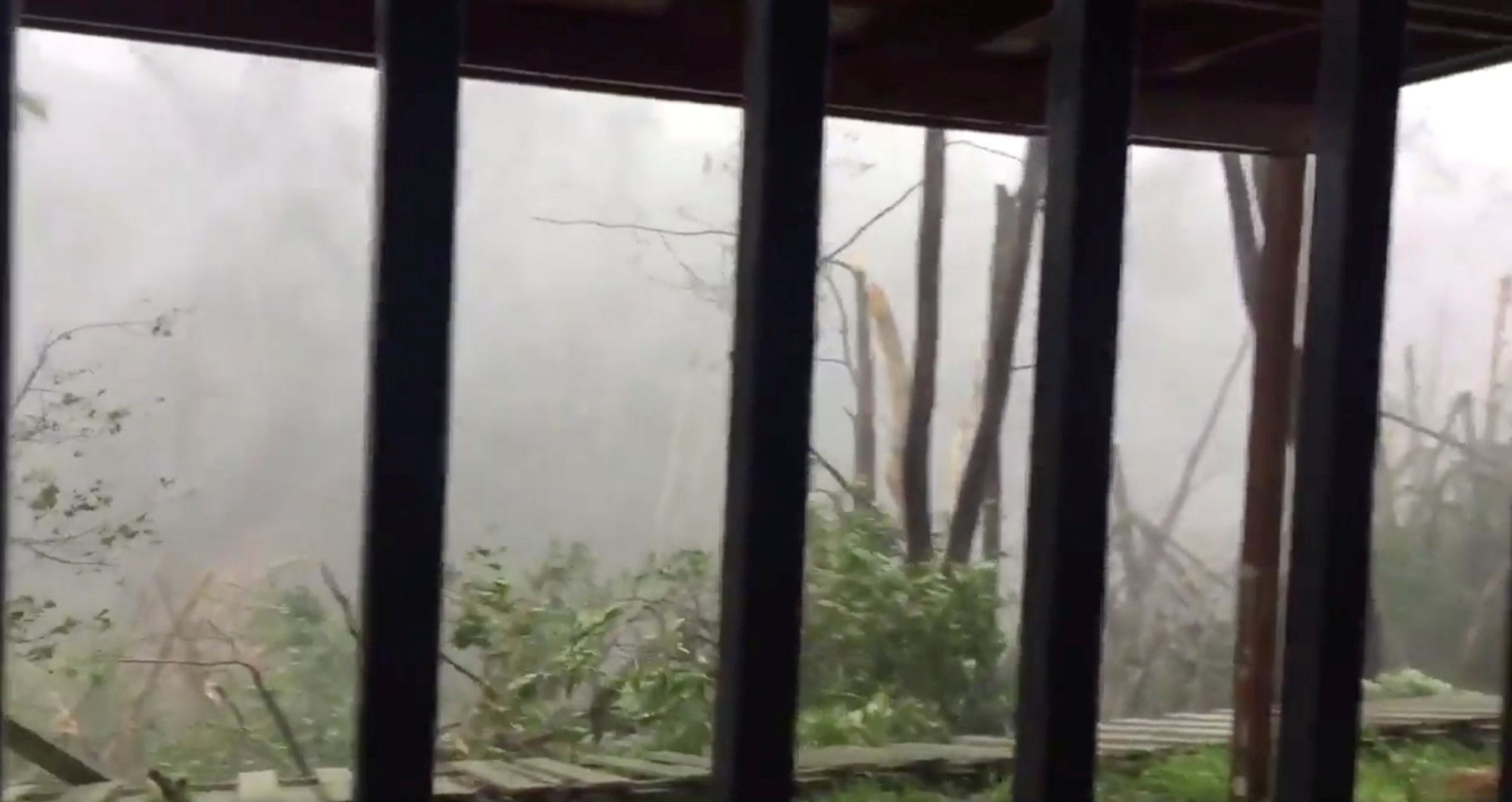 Strong winds bring down a fence of a house and causes destruction as Hurricane Maria hits Suan Juan, Puerto Rico on Sept. 20, 2017. (TWITTER/@ EAMOLERO/via REUTERS)