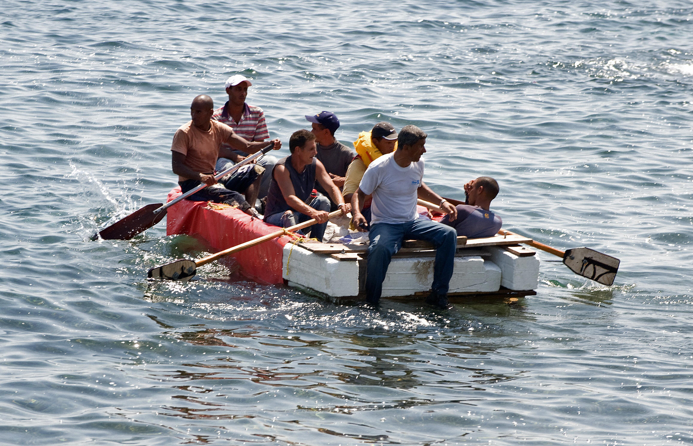 Seven would-be Cuban emigres remain in a homemade boat moments before being arrested by Cuban military agents after their attempt to escape from the island nation was thwarted by the sea currents in Havana on June 4, 2009. (ADALBERTO ROQUE/AFP/Getty Images)