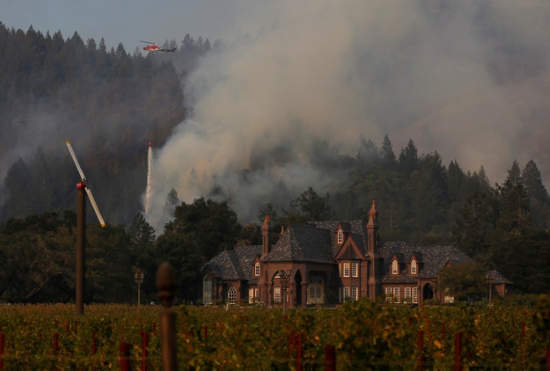 A firefighting helicopter drops water to defend a vineyard from an approaching wildfire in Santa Rosa, Calif., on Oct. 15, 2017. (REUTERS/Jim Urquhart)