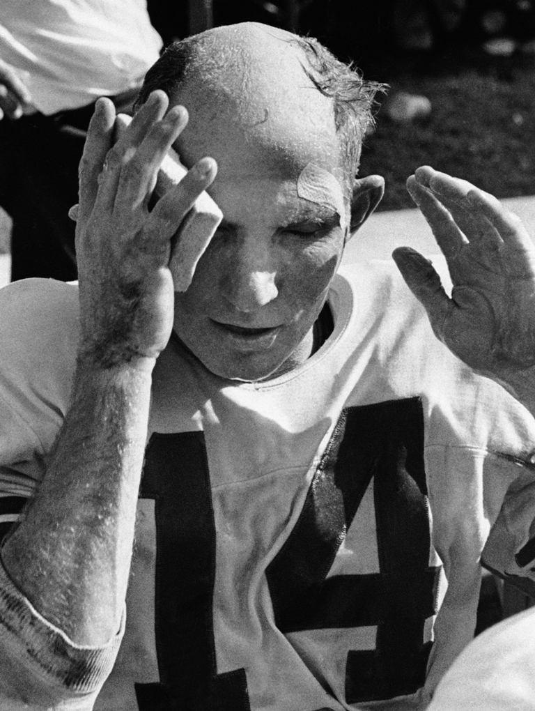 In this Oct. 7, 1962, file photo, New York Giants quarterback Y.A. Tittle wipes his face after running for a touchdown against the St. Louis Cardinals, in St. Louis. (AP Photo/File)