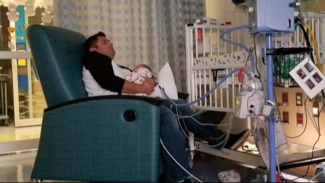 Officer Arturo Zepeda holds Axel Winch. (Aurora Police Department)