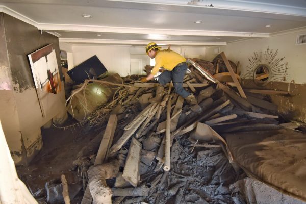 Santa Barbara County Firefighter Vince Agapito searches through a home destroyed by mudflow and debris in Montecito, California, U.S., January 13, 2018. (Mike Eliason/Santa Barbara County Fire/Handout via Reuters)