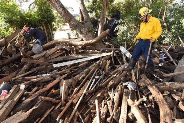Santa Barbara County Fire Capt Adam Estabrook and Engineer Rick Pinal search through a debris pile behind a home destroyed by mudflow and debris in Montecito, California, U.S., January 13, 2018. (Mike Eliason/Santa Barbara County Fire/Handout via Reuters)