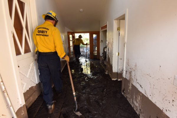 Santa Barbara County Firefighters Rick Pinal and Vince Agapito climb through a home destroyed by mudflow and debris in Montecito, California, U.S,. January 13, 2018. (Mike Eliason/Santa Barbara County Fire/Handout via Reuters)