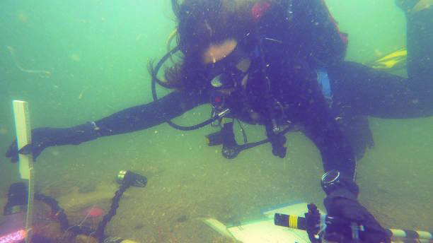 Nicole Grinnan, measures the test unit’s depth using a laser level and folding ruler. (Ivor Mollema/Florida Department of State)