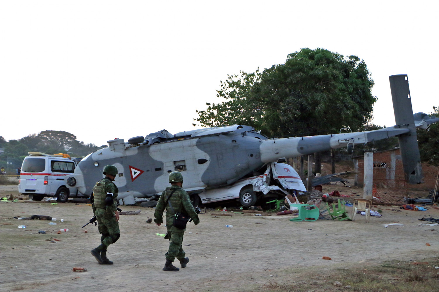 Soldiers of the Mexican army walk in front of the rugged military helicopter and van in Santiago Jamiltepec, Oaxaca state, Mexico, on February 17, 2018. (PATRICIA CASTELLANOS/AFP/Getty Images)