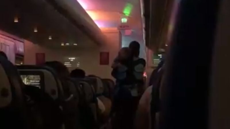 Flight Attendant Calms Down Toddler on Night Flight