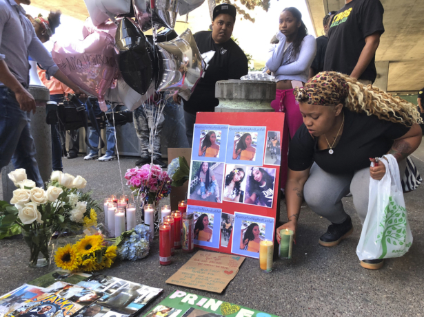 Malika Harris places a candle down for her sister Nia Wilson at a makeshift memorial outside the MacArthur Bay Area Rapid Transit station, in Oakland, Calif., on July 23, 2018. (Lorin Eleni Gill/AP)