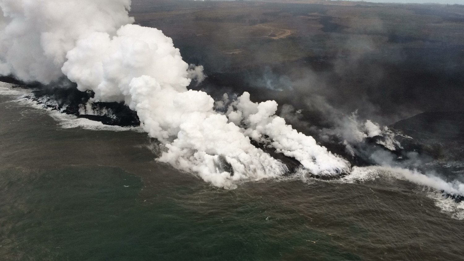 The active ocean entry along the southernmost margin of the fissure 8 flow is a hazardous area. The interaction of lava and seawater creates "laze," a corrosive steam plume laced with hydrochloric acid and fine volcanic glass particles on July 17, 2018. (USGS)