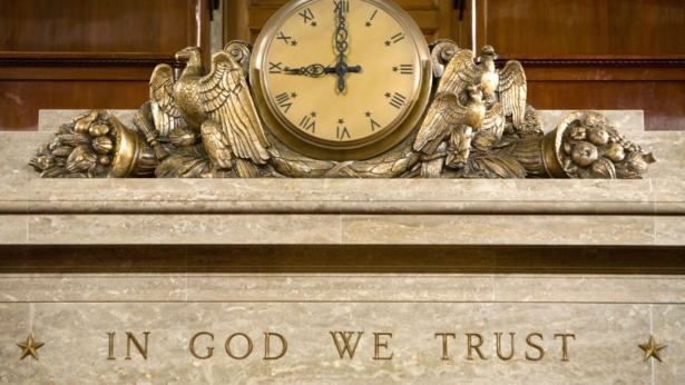 A clock and the motto "In God We Trust" over the Speaker's rostrum in the U.S. House of Representatives chamber in Washington on Dec. 8, 2008. (Photo by Brendan Hoffman/Getty Images)