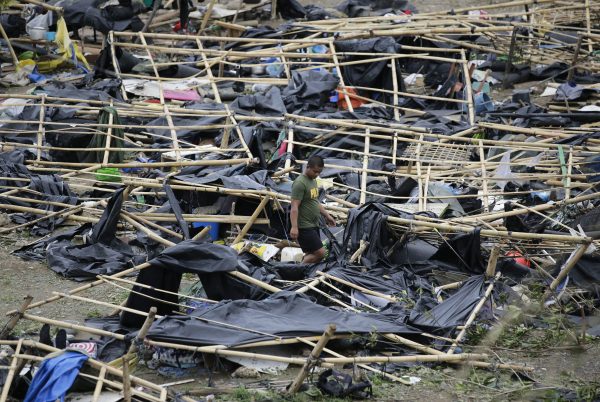 A policeman walks through makeshift tent shelters damaged by strong winds from Typhoon Mangkhut after it barreled across Tuguegarao city in Cagayan province, northeastern Philippines on Sept. 16, 2018. Typhoon Mangkhut roared toward densely populated Hong Kong and southern China on Sunday after ravaging across the northern Philippines with ferocious winds and heavy rain causing landslides and collapsed houses. (AP Photo/Aaron Favila)