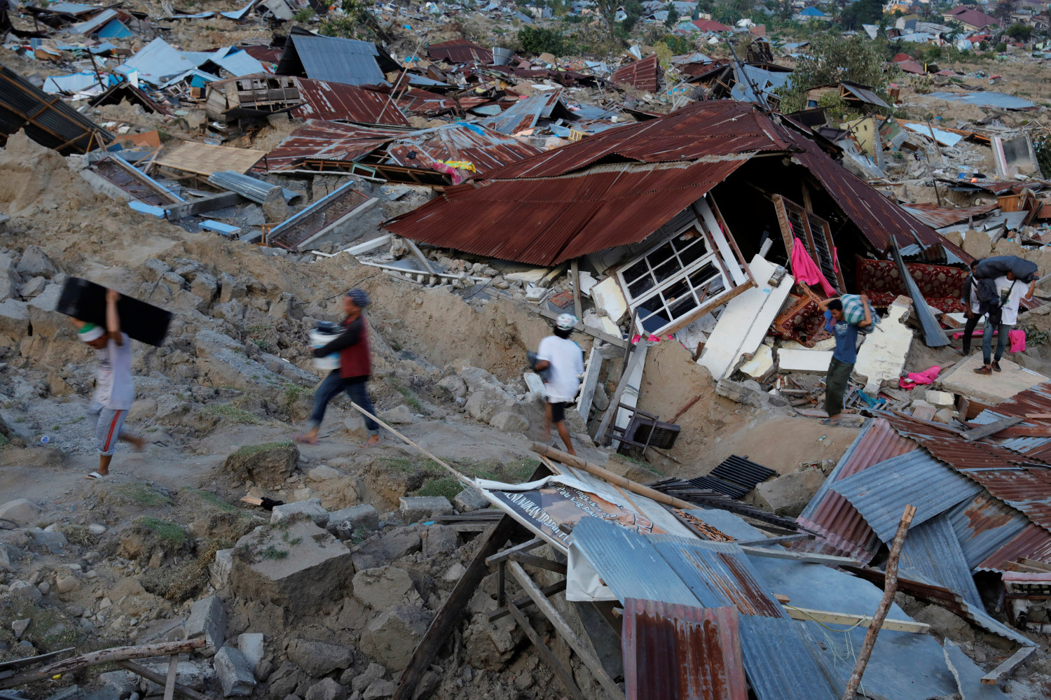Residents carry their belongings after an earthquake hit at Balaroa sub-district in Palu, Sulawesi Island. (Beawiharta/Reuters)