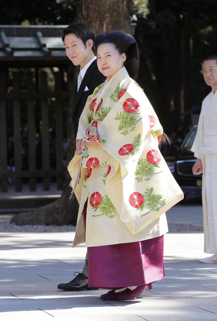 Japanese Princess Ayako, front, the third daughter of the late Prince Takamado, dressed in a traditional ceremonial gown, and Japanese businessman Kei Moriya, rear, arrive at Meiji Shrine for their wedding ceremony in Tokyo, Oct. 29, 2018. (Kyodo News via AP)