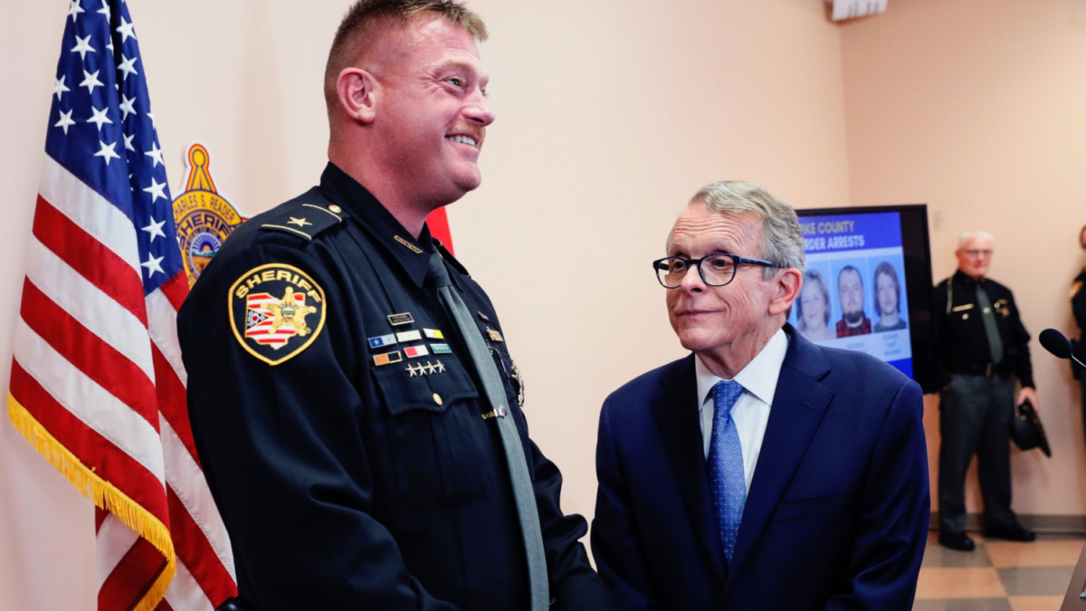 Ohio Attorney General Mike DeWine (R), smiles alongside Pike County Sheriff Charles Reader, during a news conference in Waverly, Ohio, on Nov. 13, 2018. (John Minchillo/AP)