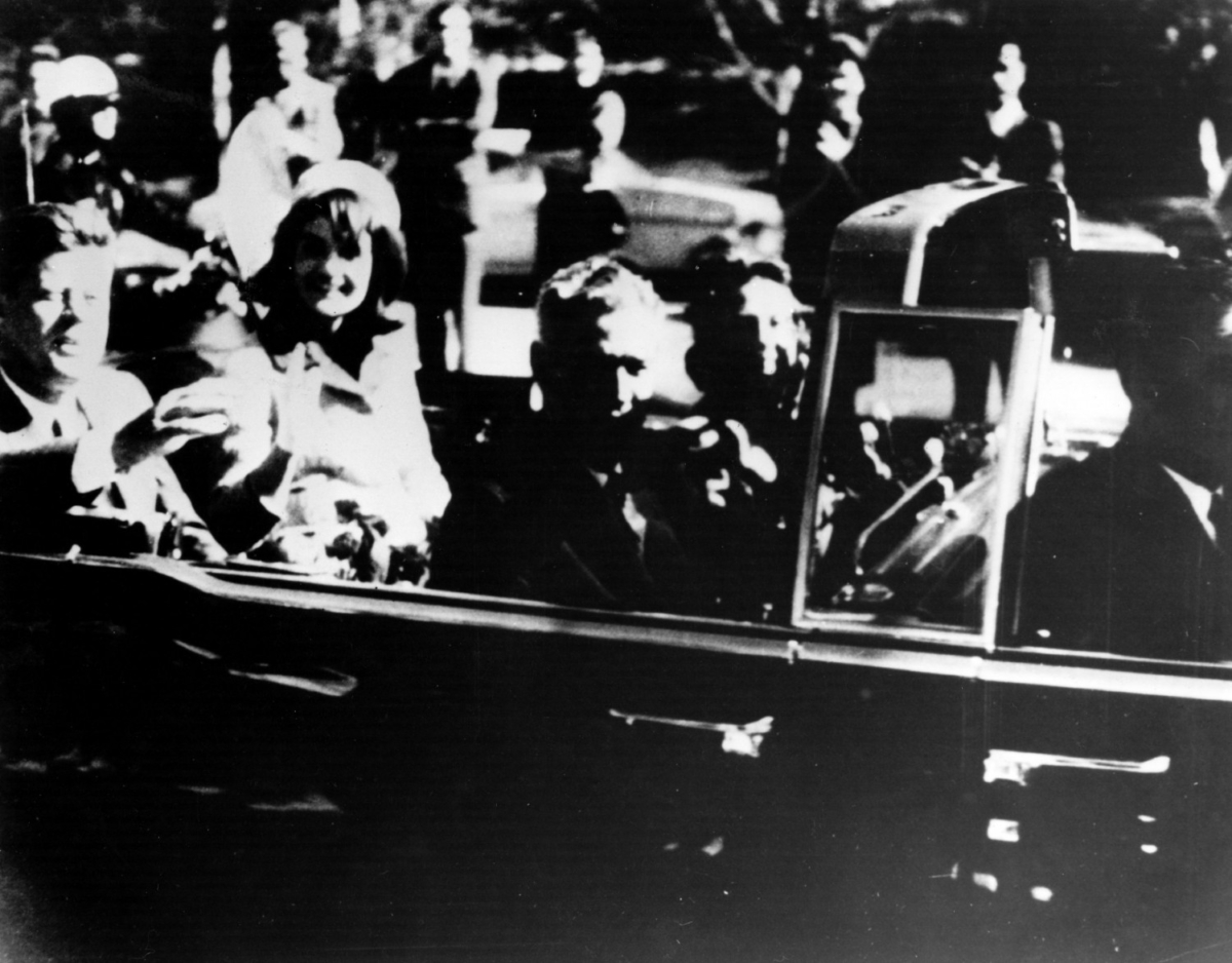 President John F. Kenned and his wife Jacqueline Kennedy ride with secret agents in an open car motorcade shortly before the president was assassinated in Dallas, Texas, on Nov. 22, 1963. (Photo by Keystone/Getty Images)