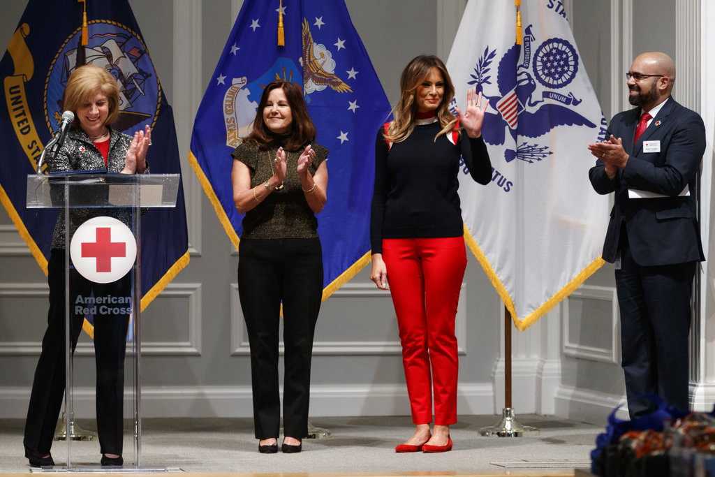 First lady Melania Trump, waves as she is acknowledged by, from left, Gail McGovern, President of the American Red Cross, Karen Pence, and Koby Langley, Senior Vice President of the American Red Cross at the Red Cross in Washington, Nov. 27, 2018, before they assemble military comfort kits that are provided to members of the military as they prepare for deployment. (AP Photo/Carolyn Kaster)