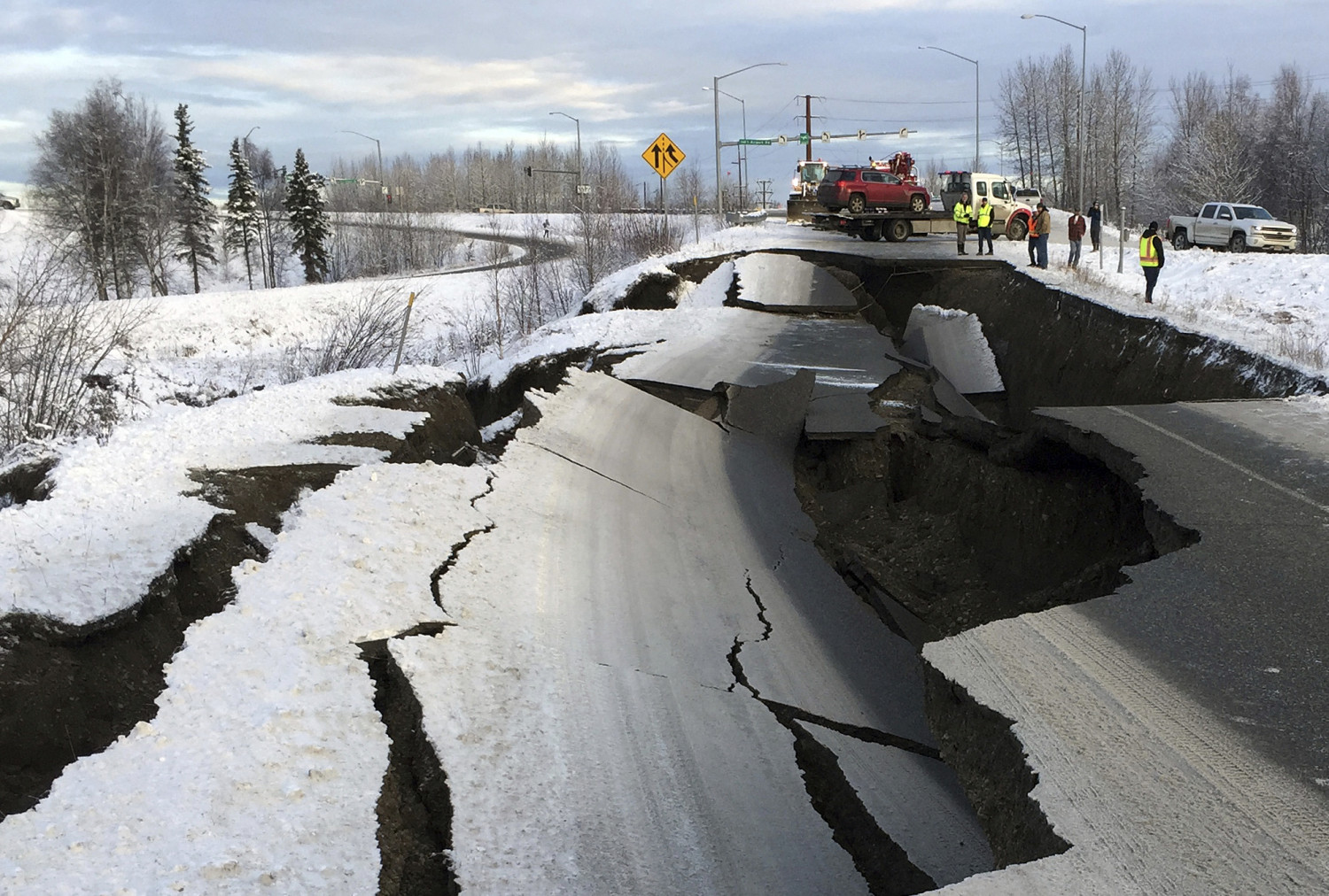 A tow truck holds a car pulled from an off-ramp that collapsed during a morning quake in Anchorage, Alaska, on Nov. 30, 2018. (Mike Dinneen/AP)