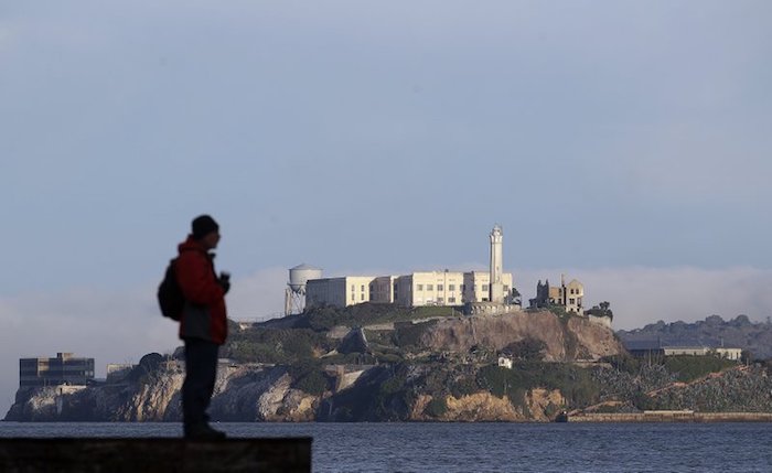 A man stands on a pier with Alcatraz Island in the background, in San Francisco, on Dec. 22, 2018. (Jeff Chiu/AP Photo)