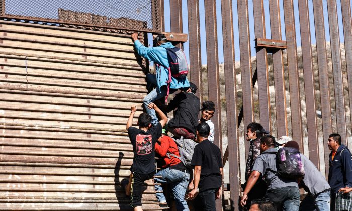Migrants break through the U.S. border fence just beyond the east pedestrian entrance of the San Ysidro crossing in Tijuana, Mexico, on Nov. 25, 2018. (Charlotte Cuthbertson/The Epoch Times)