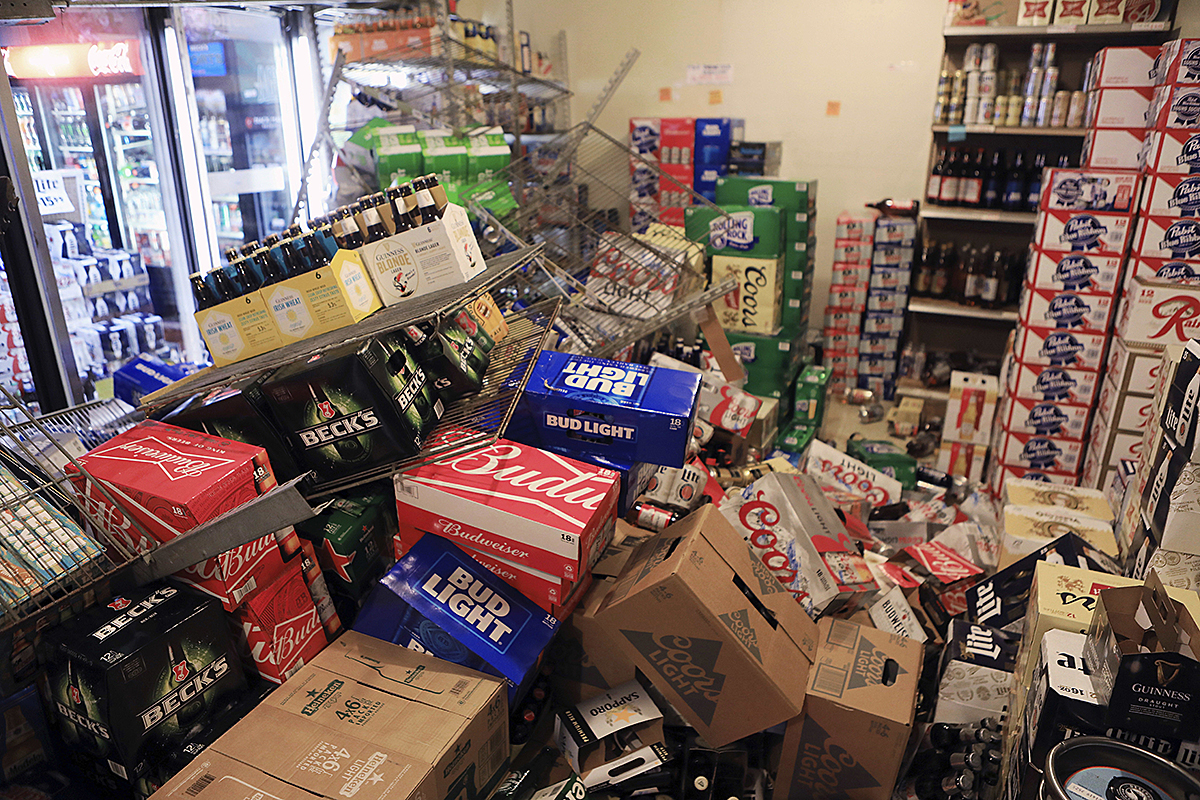 Cases of beer lie jumbled in a walk-in cooler at Value Liquor in Anchorage, Alaska after the earthquake, Nov. 30, 2018. (AP Photo/Dan Joling)