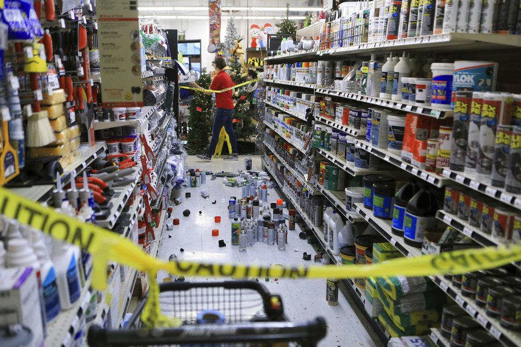An employee walks past a damaged aisle at Anchorage True Value hardware store after an earthquake on Nov. 30, 2018, in Anchorage, Alaska. (AP Photo/Dan Joling)