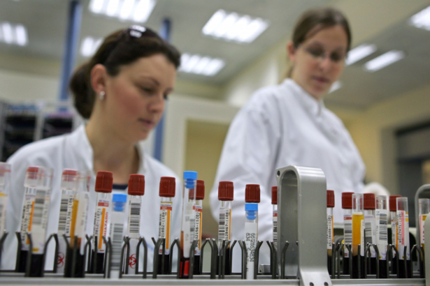 Laboratory technicians supervise as vials of human blood are processed on an automated testing line at a laboratory in Nes Tsiona, Israel, on Jan. 22, 2006. (David Silverman/Getty Images)
