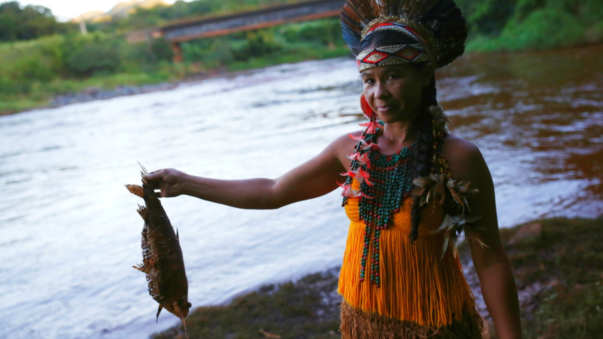 An Indigenous woman from the Pataxo Ha-ha-hae tribe holds up a dead fish near Paraopeba river, after a tailings dam owned by Brazilian mining company Vale SA collapsed, in Sao Joaquim de Bicas near Brumadinho, Brazil, on Jan. 28, 2019. (Adriano Machado/Reuters)
