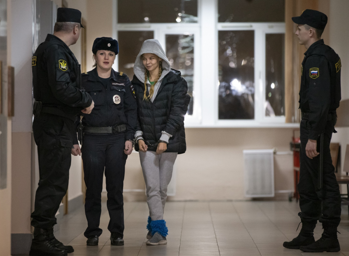 Anastasia Vashukevich, also known on social media as Nastya Rybka, center, is escorted into the court room in Moscow, Russia on Jan. 19, 2019. (AP Photo/Alexander Zemlianichenko)