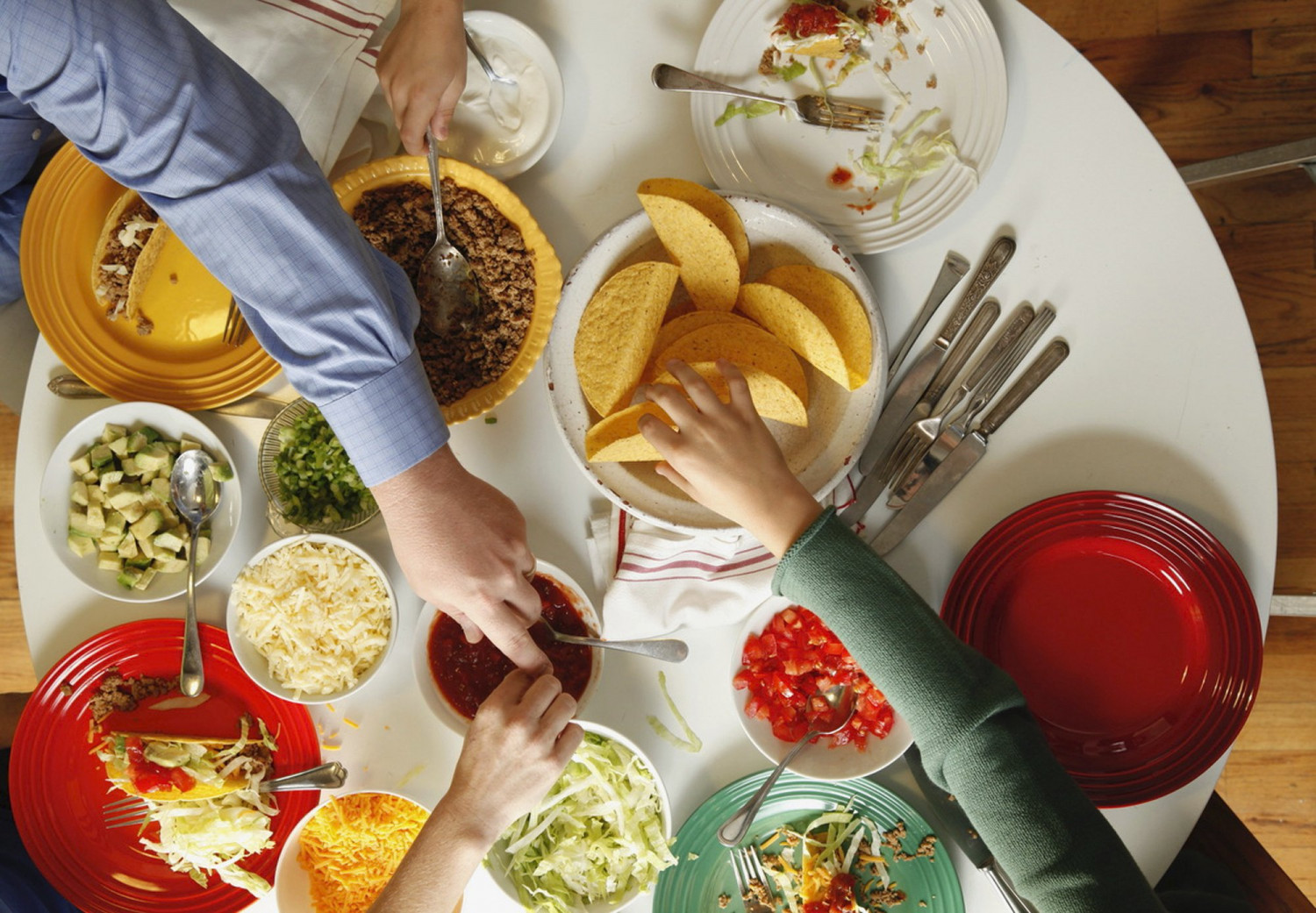 This 2012 photo provided by Katie Workman shows people accessing a taco bar set up at a home in New York. A taco bar or spread is a great interactive way to feed a crowd for the Super Bowl. (Todd Coleman/Katie Workman via AP)