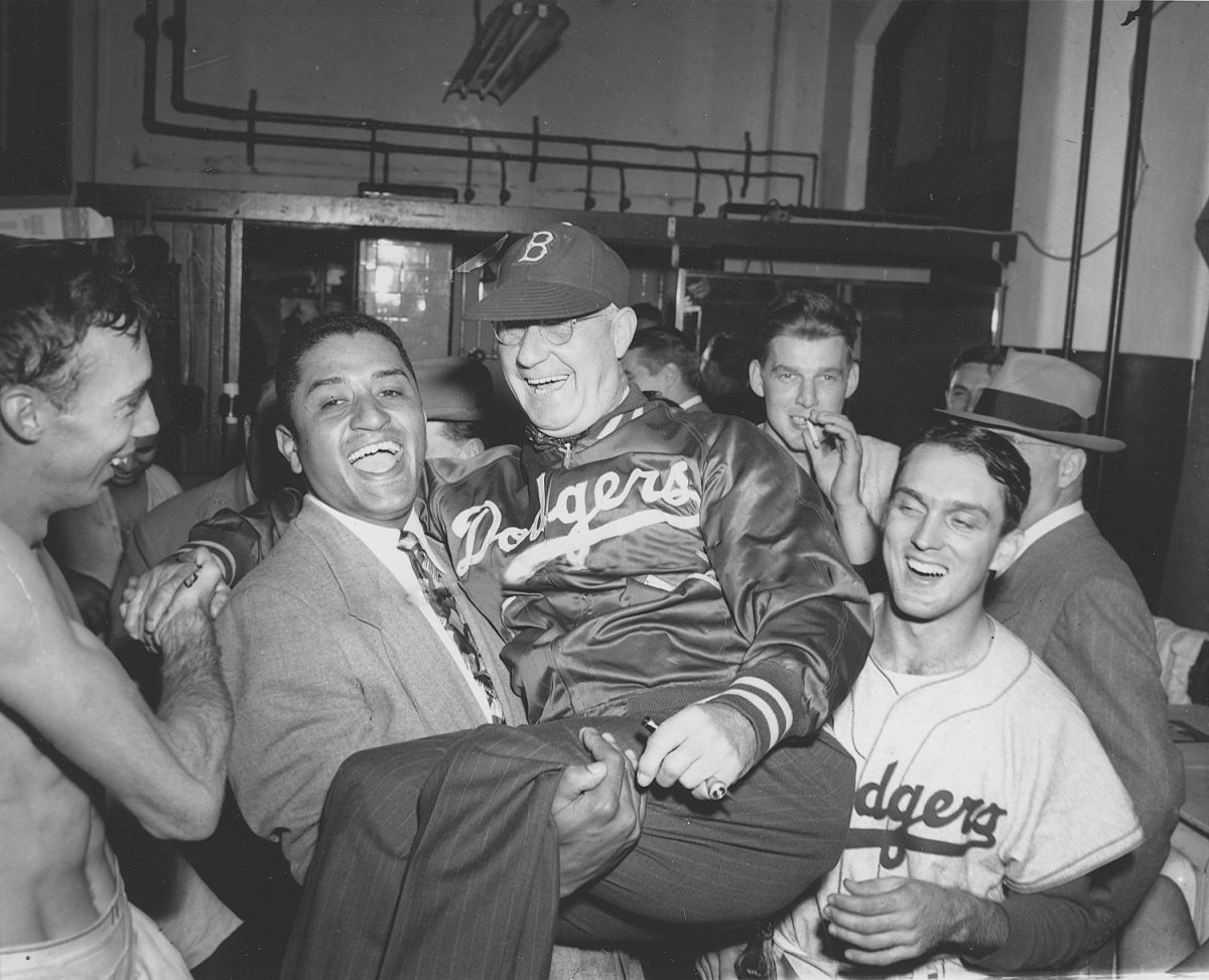 Brooklyn Dodgers pitcher Don Newcombe, second from left, holds up Dodgers manager Burt Shotton in the Dodgers dressing room after they won the National League pennant against the Philadelphia Phillies, in Philadelphia, on Oct. 2, 1949. Other players are unidentified. (Photo/AP)