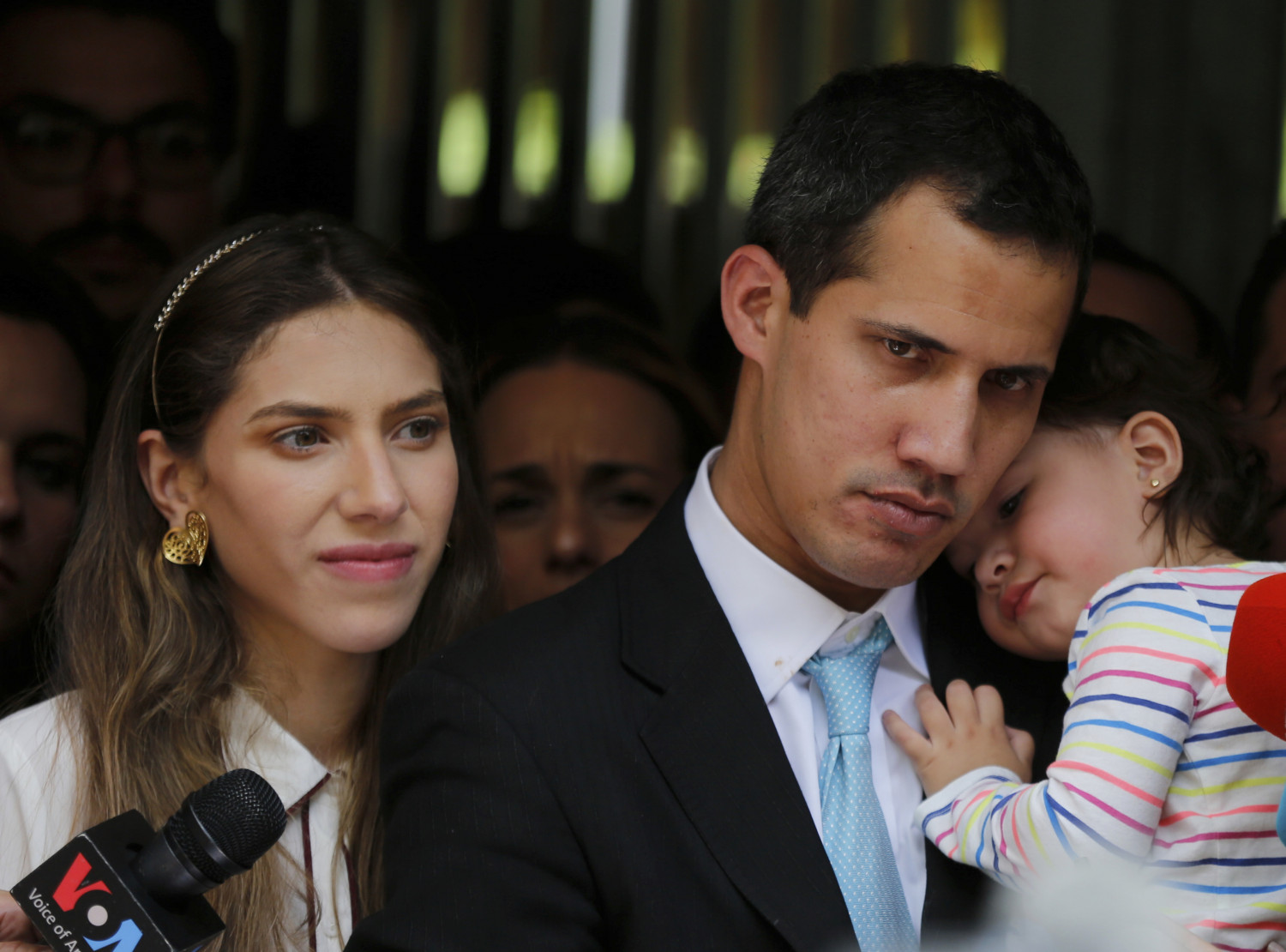 Opposition National Assembly President Juan Guaido, accompanied by his wife Fabiana Rosales and his 20-month-old daughter Miranda, listens to a reporter's question during a news conference outside their apartment, in Caracas, Venezuela, Thursday, Jan. 31, 2019. Guaido said security forces showed up at their home in an attempt to intimidate him. "The dictatorship thinks it can intimidate us," Guaido said. (AP/Fernando Llano)