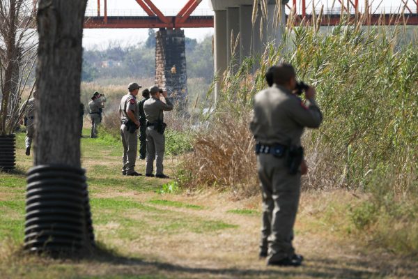 Texas State Troopers and Border Patrol agents watch several migrants attempt to cross the Rio Grande into the United States illegally at Eagle Pass, Texas, on Feb. 16, 2019. (Charlotte Cuthbertson/The Epoch Times)