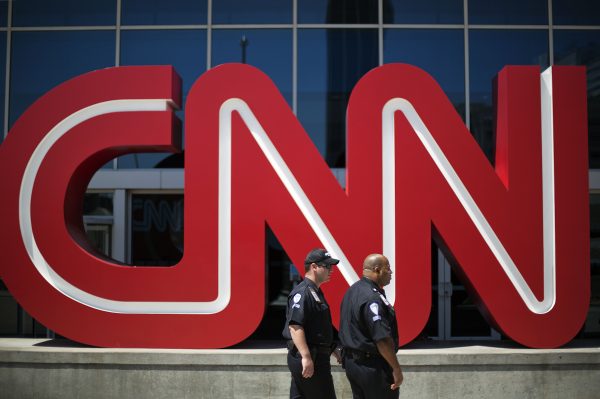 Security guards walk past the entrance to CNN headquarters in Atlanta. (AP Photo/David Goldman, File)