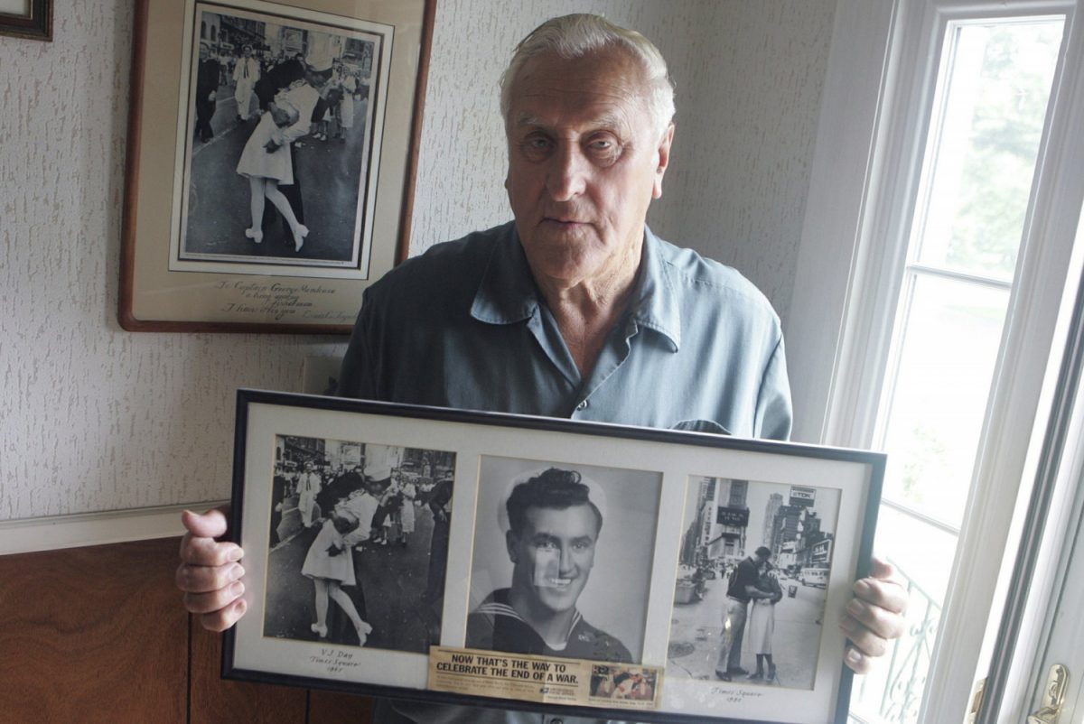 George Mendonsa poses for a photo in Middletown, R.I., holding a copy of the famous Alfred Eisenstadt photo of Mendonsa kissing a woman in a nurse's uniform while celebrating the end of World War II in Times Square on Aug. 14, 1945. (Connie Grosch/Providence Journal via AP)