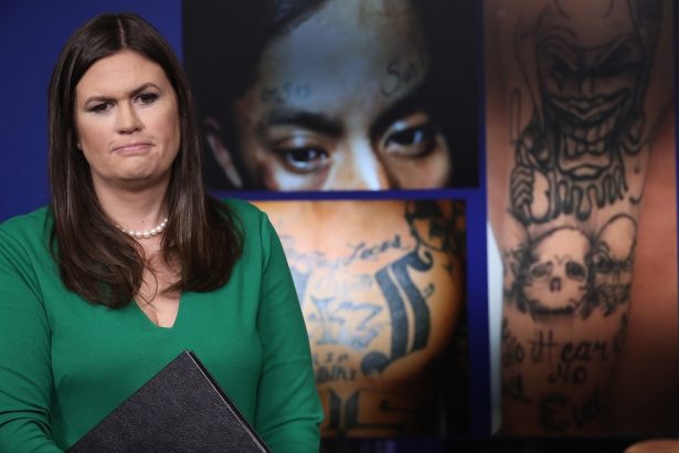 White House Press Secretary Sarah Huckabee Sanders stands in front of gang-related photos from the MS-13 gang during a daily briefing at the White House on July 27, 2017. (Win McNamee/Getty Images)