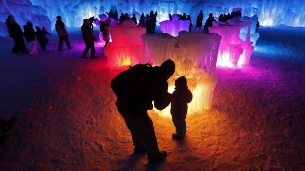 Bruce McCafferty and his son, Dougie, pause while exploring the ice formations growing at Ice Castles in North Woodstock, N.H. on Jan. 26, 2019. (Robert F. Bukaty/AP Photo)