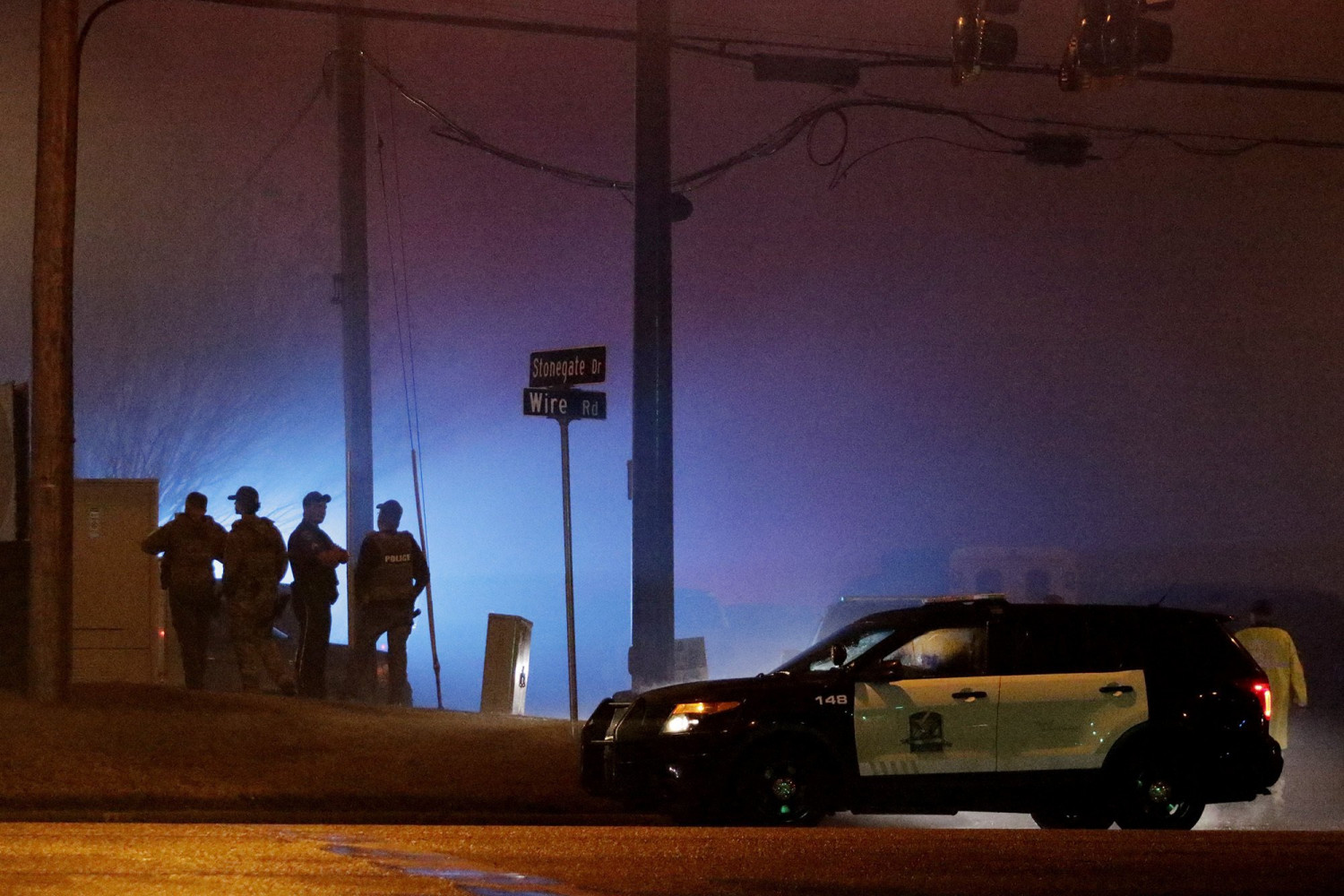 Law enforcement officers stand at the corner Stonegate Drive