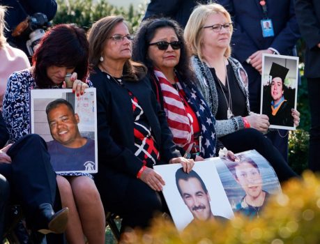 Family members hold portraits of loved ones that were victims of crimes committed by illegal aliens, as President Donald Trump delivers remarks, in the Rose Garden at the White House, on Feb. 15, 2019. (Brendan Smialowski/AFP/Getty Images)