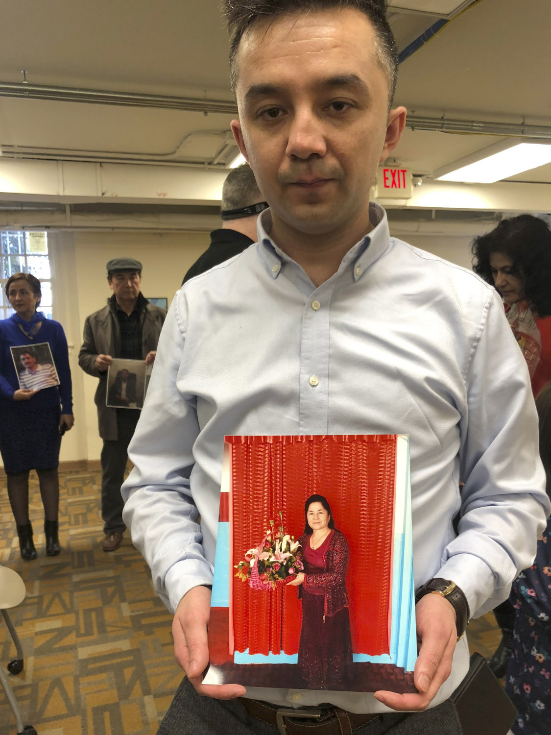Fermat Jawdat holds up a photo of his mother during a gathering to raise awareness about loved ones who have disappeared in China's far west, in Washington DC on Sunday, Feb. 24, 2019. In recent years, Xinjiang has been subject to a severe security crackdown which the Chinese government says is necessary to fight latent religious extremism. The dragnet has made surveillance cameras and police checkpoints ubiquitous and placed an estimated 1 million Uighurs and others in extrajudicial internment camps. (Christina Larson/AP Photo)