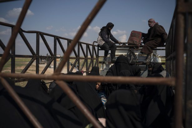 Men, women, and children ride in the back of a truck in a convoy evacuating hundreds out of the last territory held by ISIS terrorists in Baghouz, eastern Syria on Feb. 22, 2019. (Felipe Dana/AP Photo)