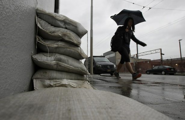 A woman walks past sandbags blocking an entry to a business in San Francisco, on Feb. 1, 2019. (Jeff Chiu/AP Photo)