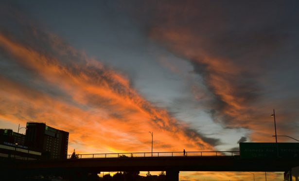 A pedestrian makes their way across an overpass under a dramatic sunrise during the early morning commute in Los Angeles on Feb. 1, 2019. (Richard Vogel/AP Photo)