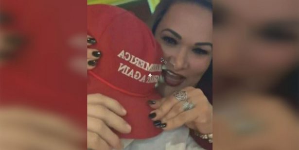 woman grabs maga hat