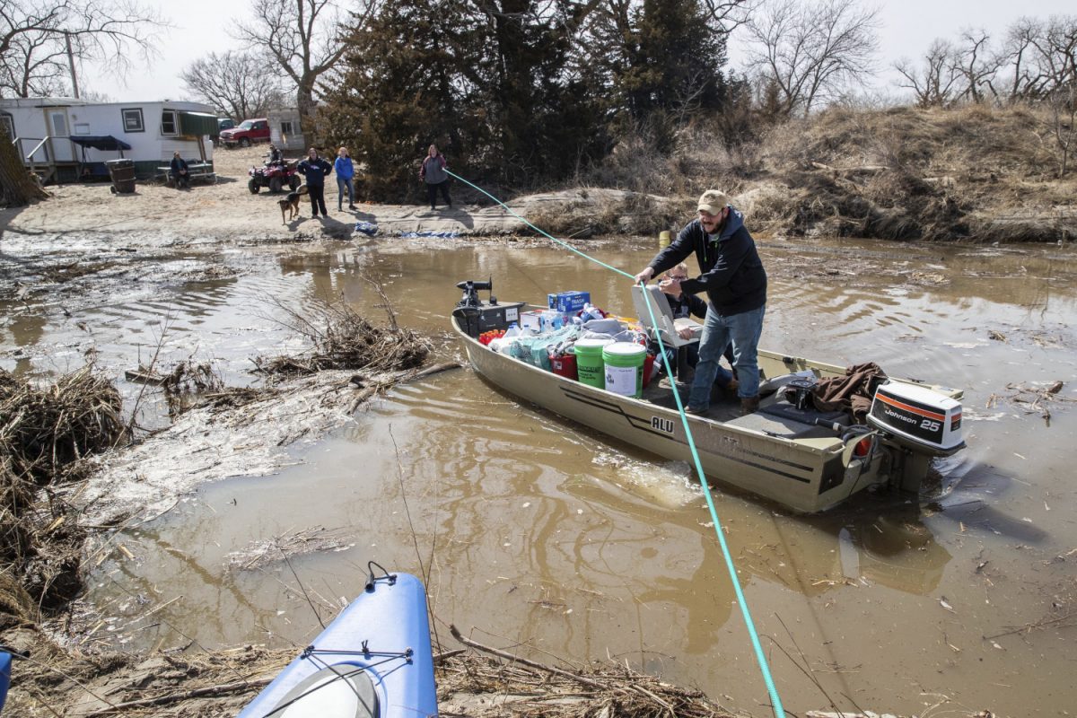 A boat brings supplies to the Bellwood Lakes area, Bellwood, Neb. March 18, 2019. (Bredan Sullivan/Omaha World-Herald/AP)